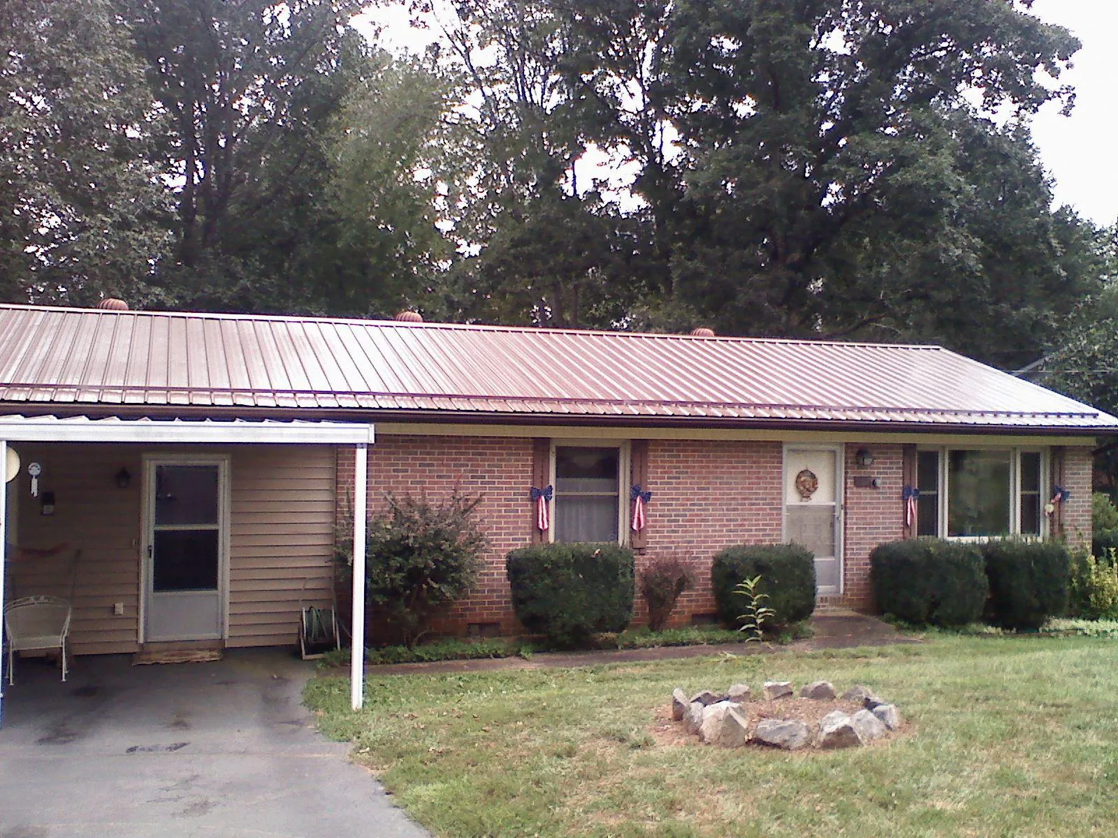 Bronze metal roof and carport on a brick ranch home — Roof Repair work by our crew in Chilhowee